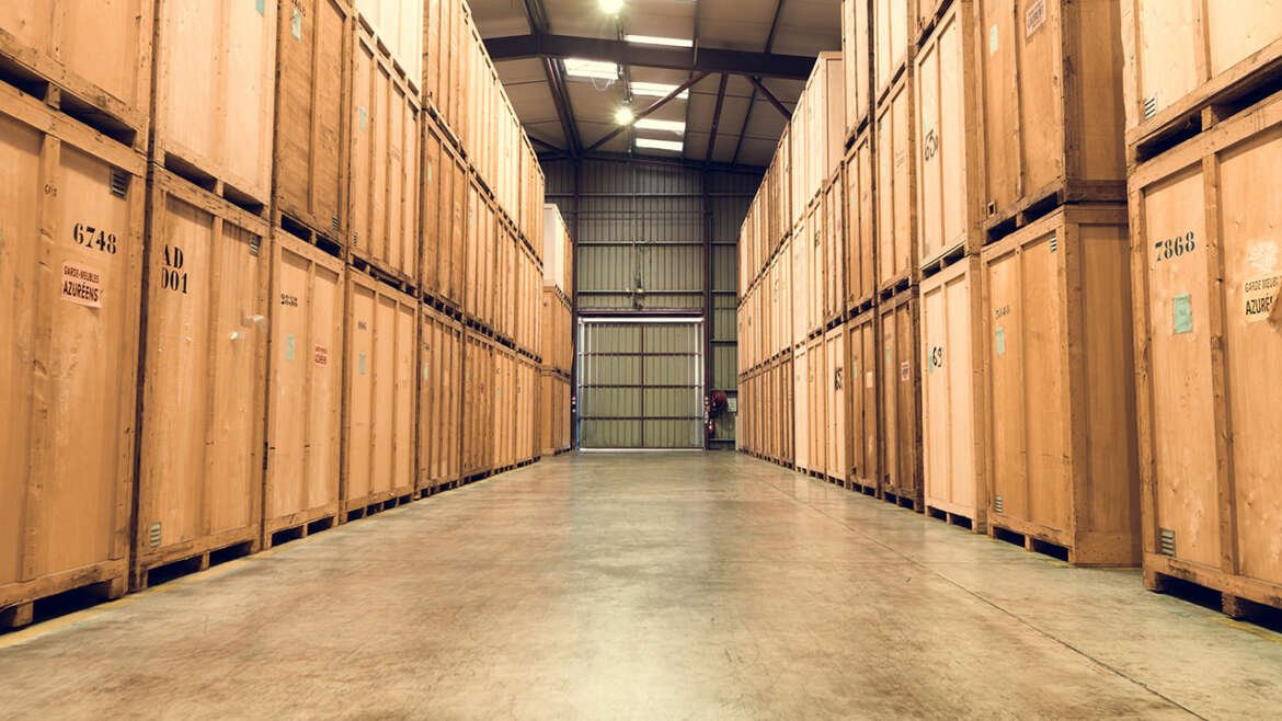 Allée d’entrepôt avec caisses en bois individuelles pour garde-meubles sécurisé